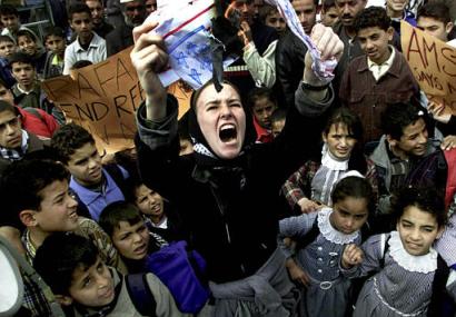 Rachel Corrie, 23, from Olympia, Wash., a member of the 'International Solidarity Movement,' burns a mock U.S. flag during a rally in the southern Gaza Strip town of Rafah in this Feb. 15, 2003 file photo. Corrie was run over and crushed to death by an Israeli army bulldozer Sunday, March 16, 2003, while she was trying to stop it from tearing down a building in the Rafah refugee camp, witnesses said. (AP Photo/Khalil Hamra)